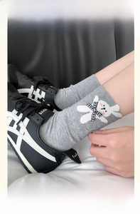 Detail of grey calf-high socks with cute white rabbit patch and checkered bow tie decor