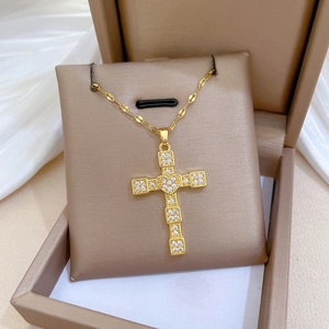 Detailed view of a gold cross necklace with crystal heart center in a premium gift box