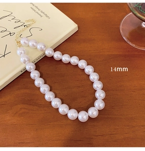 Detail of 14mm large pearls on a vintage necklace with a gold-tone lobster clasp