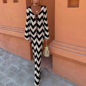 Robe longue en maille à motif chevron noir et doré avec un décolleté en V profond