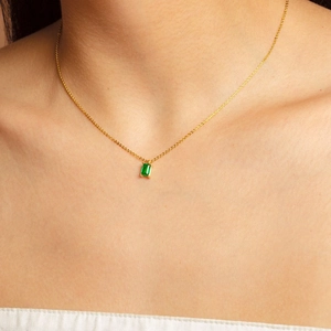 Détail d'un collier plaqué or 18 carats avec pendentif rectangle en zircon vert émeraude