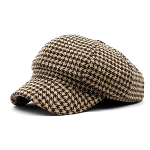 Detailed view of houndstooth newsboy hat fabric with gold metallic thread and thick texture