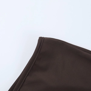Détail des coutures fines et du tissu marron foncé de haute qualité de la combinaison