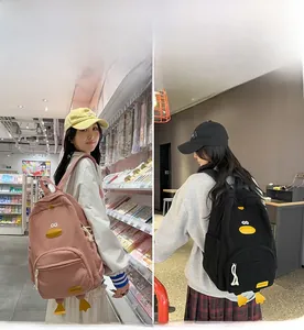 Detail of pink and black corduroy backpacks with 3D cartoon duck features