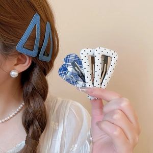 Dettaglio di fermagli per capelli in tessuto con motivi denim, scozzesi e a pois