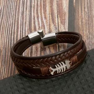 Detail of brown braided leather bracelet with silver fishbone charm and magnetic clasp