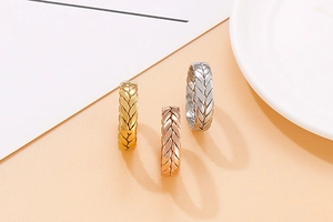 Dettaglio degli anelli a trama intrecciata in finiture oro, oro rosa e argento