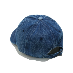Detailed view of dark blue denim baseball cap showing premium texture and metal buckle
