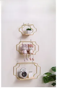 Three-piece gold metal geometric wall shelves with wood base and decorative home items