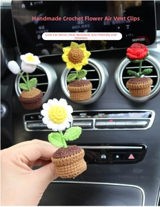 Detailed macro view of hand-knitted flower pot vent clips on a car air conditioner