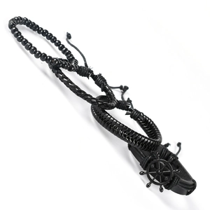 Detail shot of multi-layer black leather bracelets with a metal ship wheel charm