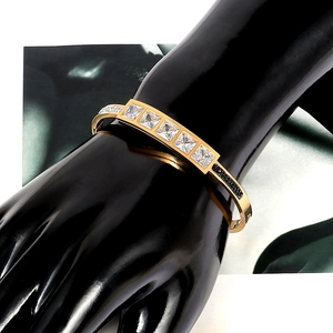 Gold plated stainless steel bangle featuring square white zircons and black crystal accents