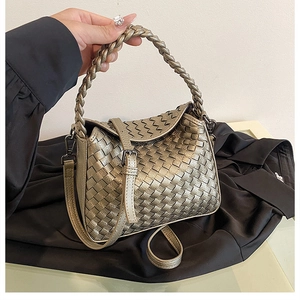 Close-up of handmade woven texture and light gold finish on a versatile crossbody handbag