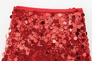 Macro detail of high-density red sequins and stitching on the stylish A-line skirt