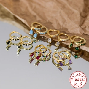 Macro shot of 925 sterling silver hoop earrings with colorful teardrop gemstones