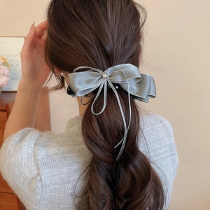 Silver bow hair clip with zircon star detail worn on a high ponytail for elegant styling