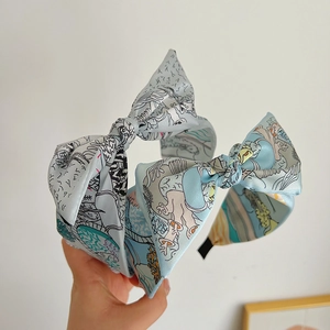 Detail of light blue floral double bow headband with vintage illustration patterns