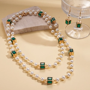 Elegant multi-layered pearl necklace and earrings set with emerald green cubic accents