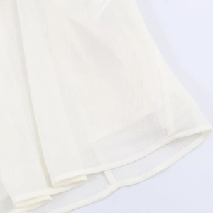 Detailed close-up of white chiffon fabric showing hem stitching and sheer pleated texture