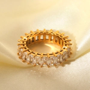 Gold stainless steel eternity band ring with baguette cut cubic zirconia on silk