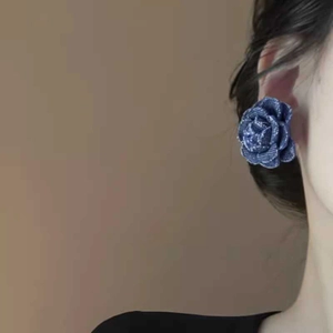 Gros plan de boucles d'oreilles rose en tissu denim bleu portées par un mannequin