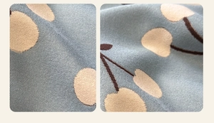 Close-up of soft blue knit scarf fabric with cute cherry pattern and thick texture