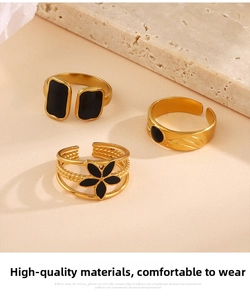 Drei 18K vergoldete Ringe mit schwarzer Emaille-Blume und geometrischen Details in Nahaufnahme
