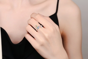 Detail of adjustable butterfly ring featuring colorful cubic zirconia on model's hand