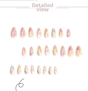 Close-up of almond press-on nails featuring colorful stars and white cloud patterns