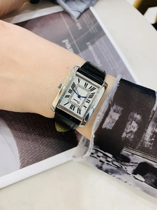 Classic rectangle silver watch with black leather strap worn on a woman's wrist