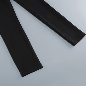 Detailed close-up of high-waist black jumpsuit legs featuring premium knit fabric
