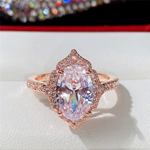 Rose gold halo ring with large oval crystal and pavé diamonds in a white jewelry box