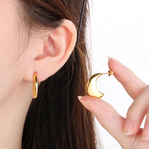 Vue détaillée des boucles d'oreilles lune dorées polies au design épais en forme de U