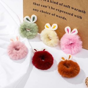 Detail of six plush bunny ear hair scrunchies in assorted candy colors with soft faux fur