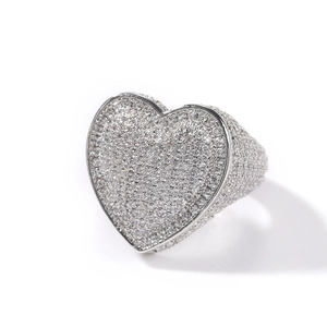 Macro shot of silver hip hop heart ring with 3A zircon pavé setting on white background