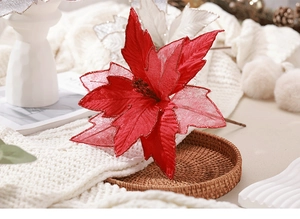 Close-up of artificial red poinsettia flower with glitter in a rustic Christmas setting