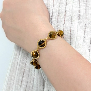 Detail of vintage turquoise style bracelet with golden tiger eye beads on wrist