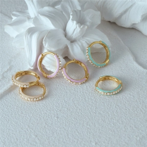Macro detail of S925 sterling silver stamp on colorful enamel and diamond hoop earrings