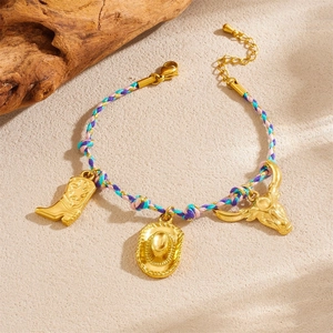 Detail of colorful woven bracelet with gold cowboy boot, hat, and bull head charms