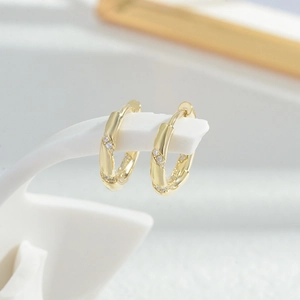 Elegant gold plated spiral hoop earrings set with sparkling white zircon stones