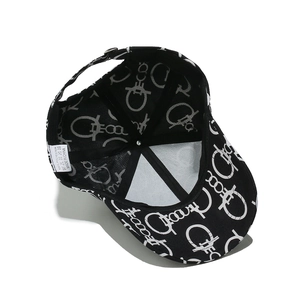 Detail of baseball cap interior showing woven fabric, metal top button and wash care label