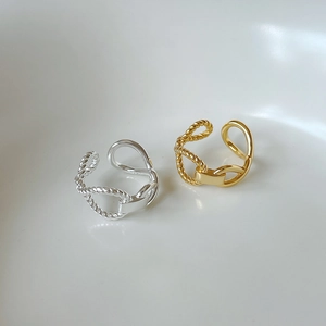 Macro shot of S925 sterling silver braided twist rings in gold and silver finishes