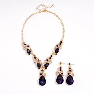 Vintage gold jewelry set with purple teardrop crystals and sparkling rhinestones