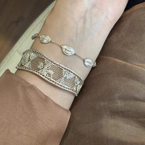 18k gold plated hollow geometric cuff bracelet and filigree chain on satin background