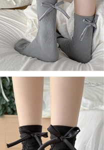 Detail of grey knitted mid-calf socks featuring a 3D bear jacquard and silk ribbon bow