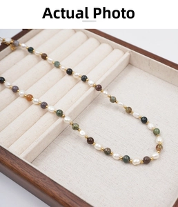 Close-up of mixed natural stone beads and freshwater pearls in a wood jewelry box