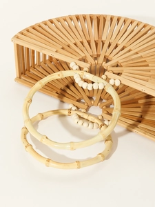 Detail view of handmade semi-circular bamboo woven bag with beaded ring handles
