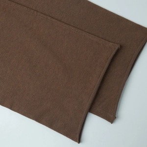 Vue détaillée du tissu en maille marron foncé montrant la texture fine et l'ourlet