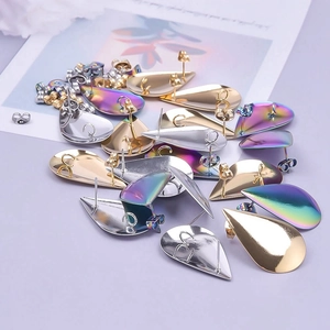 Detailed view of teardrop stud earrings in gold, silver, and iridescent rainbow finishes