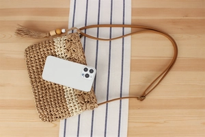 Vue détaillée du sac bandoulière en paille tressée avec glands et perles de bois et mobile